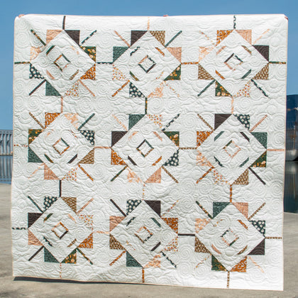 A quilt with a geometric star pattern featuring various colors.